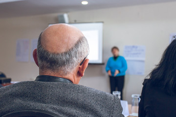 Obraz premium Speaker giving presentation in lecture hall. Participants listen