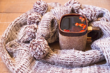 Mug of tea rosehip wrapped warm scarf