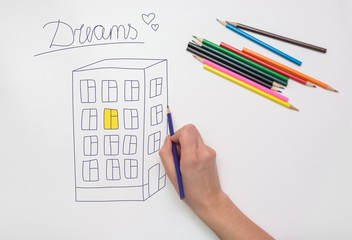 Hand painted on the drawing paper with crayons multi-storey building, light in the apartment and the inscription dream