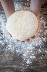 Hands holding a finished clean dough