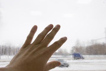 Hand concerns blurred from rain window