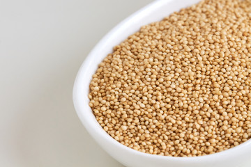 Amaranth grain in bowl on white background. Copy space