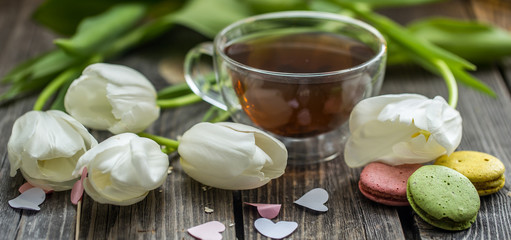 Fototapeta na wymiar white tulips and a transparent Cup of tea
