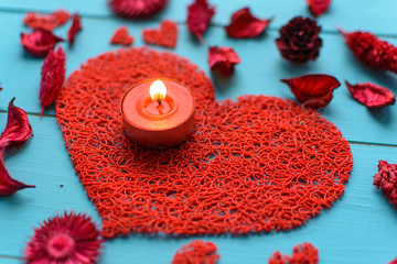 Fototapeta na wymiar Candles, flowers, petals, hearts on the blue board