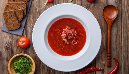 Beet soup in white plate with vegetables