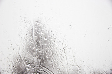 Flowing water drops on blurred glass