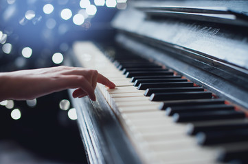 girl playing on an old piano. Beautiful blur background