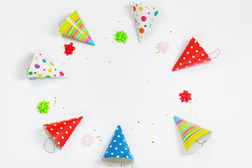 Greeting card for carnival party. Party hat and confetti on ligh