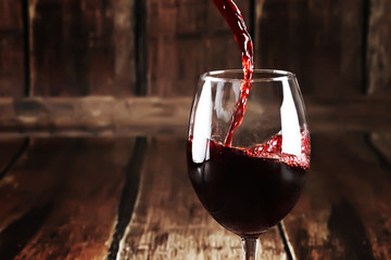 Naklejka na ściany i meble Close up of pouring wine in glass