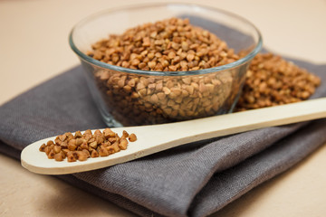 Buckwheat groats in bowl and wooden spoon