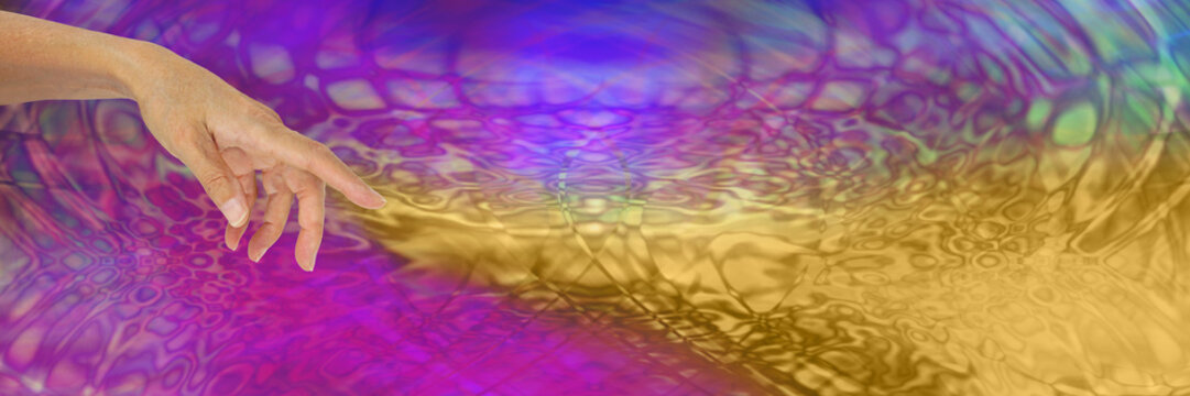 The Alchemist - female hand with index finger pointing and a stream of gold flowing out across the wide background of pink and purple psychedelic pattern