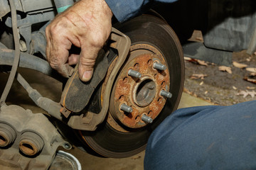Removing automotive front disk brake show from carrier.