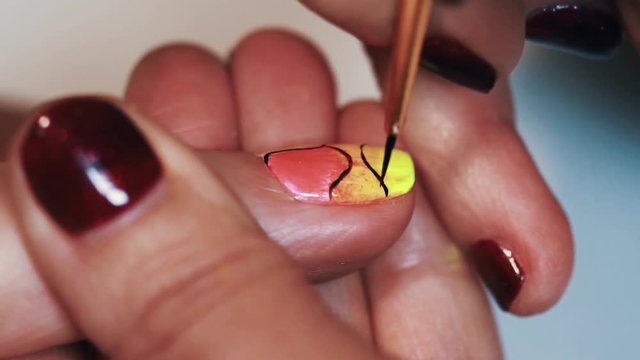 Manicurist woman hand draw abstract pattern on colorful nail polish beauty shop, close up