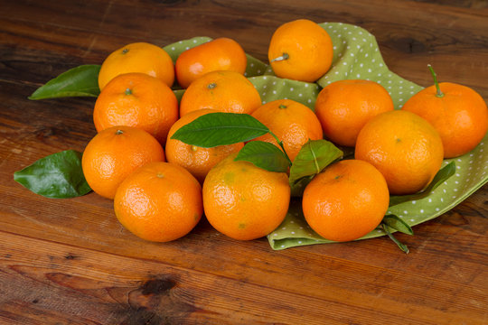 tangerines with green napkin on dark wooden background