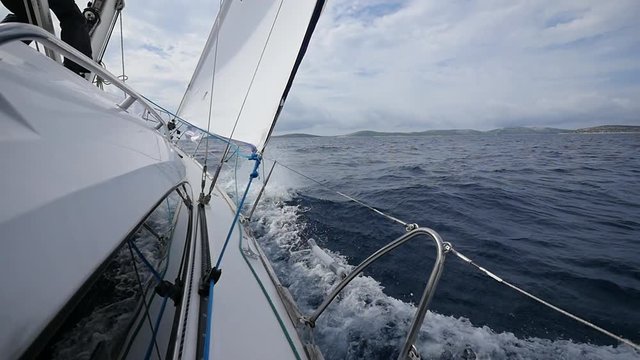 Deck and aboard yacht on background of sea waves in Greece. In general plan. Regatta. Adventures in the ocean. Slow motion.