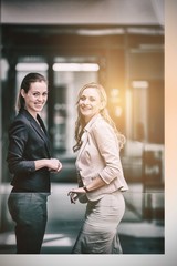 Happy businesswomen standing in office