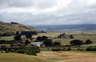 Broad panorama of the countryside in Victoria with green field in foreground. Grassy hills near Glenaire in Australia. Rural landscape near the forest in mountains. Hillside landscape.