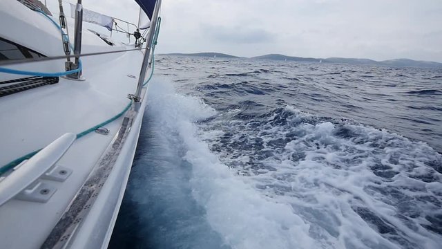 Aboard and handrails yacht on background of sea waves in Greece. Regatta. Adventures in the ocean. Slow motion.
