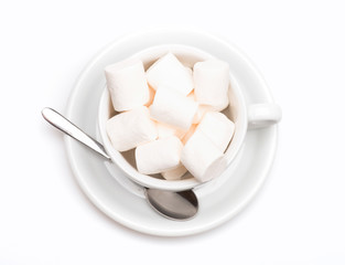 cup with marshmallow on plate with spoon