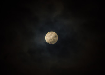 Full moon on cloudy black sky as background
