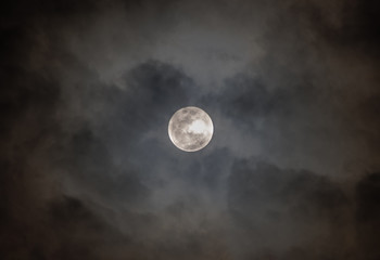 Naklejka na ściany i meble Full moon on cloudy black sky as background