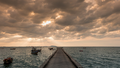 Local fisherman boats at pier in the evening against sunset skies (sunset dusk lighting)