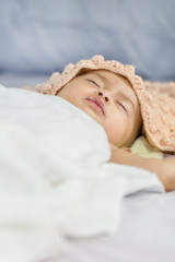 Baby sleeping on bed in the bedroom