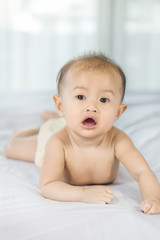 portrait of baby on a bed in bedroom