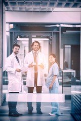Obraz premium Doctor holding digital tablet standing with colleagues