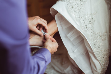 groom help to wear bridal shoes