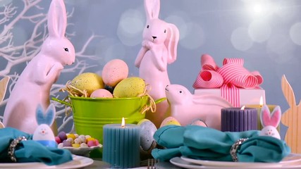 Happy Easter table setting with pink bunny and Easter Eggs centerpiece, and moving bokeh lights and lens flare, close up panning. - Powered by Adobe