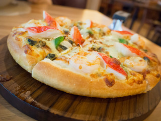 Delicious seafood pizza on wooden table