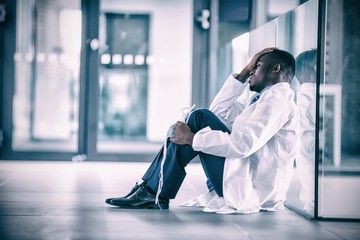 Worried doctor sitting floor