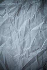 Recycled crumpled gray paper background dark edged.