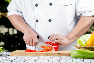 Chef cutting tomato