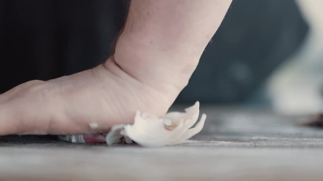 Chef Crushing Clove of Garlic with Hands in Kitchen, Slow Motion