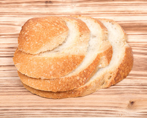 Sliced crusty country style round organic french bread isolated on wooden vintage tray