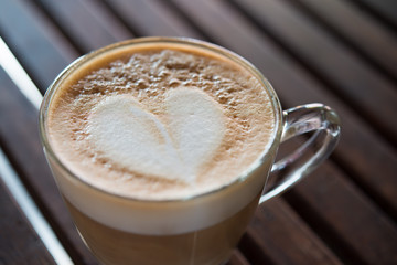 Close up of cappuccino cup with heart shaped milk pattern at caf