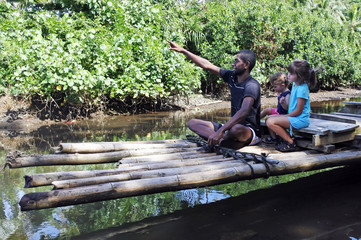 Indigenous Fijian man building a traditional Fijian bamboo boat
