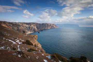Fototapeta na wymiar High cliffs over the sea under a blue sky with clouds. Fiolent.