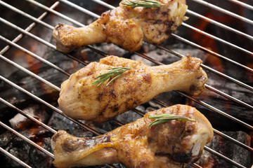 Grilled chicken drumstick over flames on a barbecue