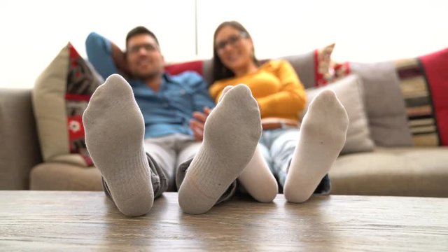 Closeup of couple's feet laid on table