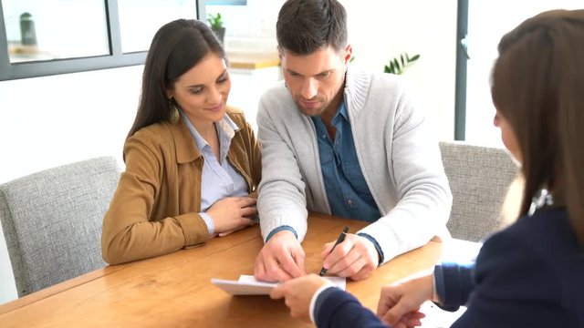 Couple meeting financial adviser for home investment contract