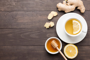 Cup of ginger tea with lemon and honey on wooden background. 