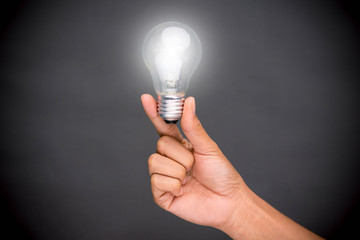 hand holding Light bulb on backwood background