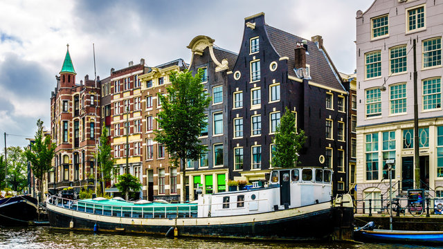 Historic houses dating back to the Middle Ages along the canals seen from a boat in canals of Amsterdam