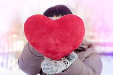 Woman holding a big red fluffy heart. for Valentine's day. hearth of love