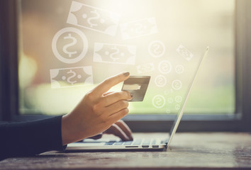 Woman Hands holding credit card and using laptop. Online shopping and get money from internet