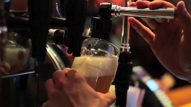 Barman Pouring Pint of Beer behind Bar