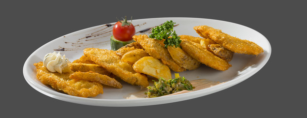 fried potatoes garnished with tomato and cucumber on a plate iso